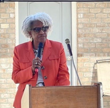 A woman speaking behind a podium.