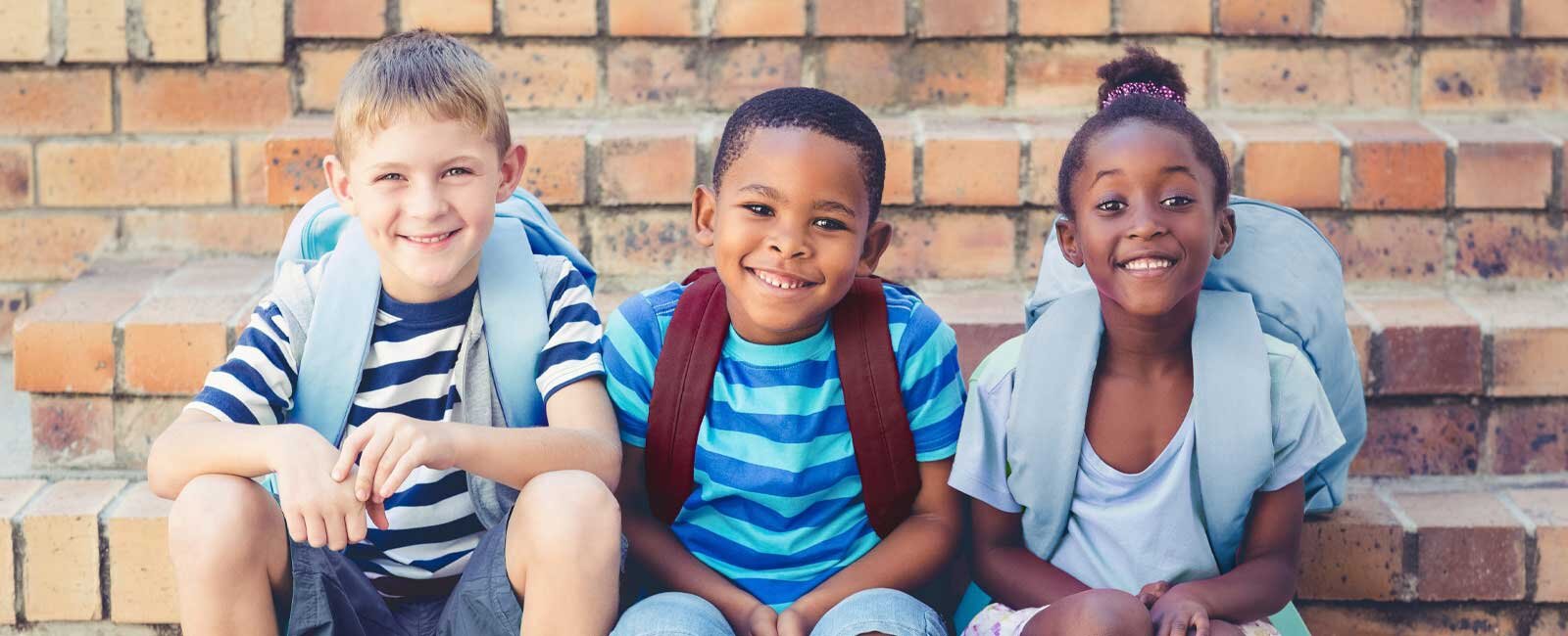 Three schoolchildren with backpacks