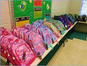 Donated backpacks laid out on table