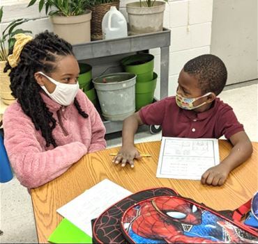 Student Megan McDonald tutoring elementary boy