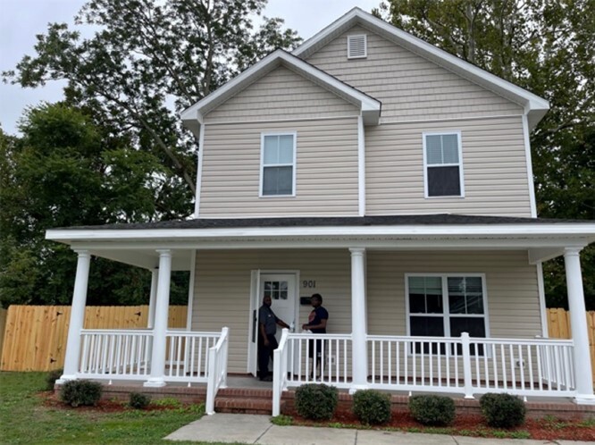 Front view of a house with a man and boy standing out front. 