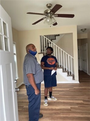 A man and his son standing in a living room. 