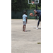  A man showing a young girl how to shoot a basketball.