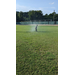 A boy standing in a sprinkler.