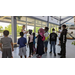 A group of students listening to a Museum worker speak.