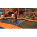 Three girls bouncing on a trampoline at an indoor park. 