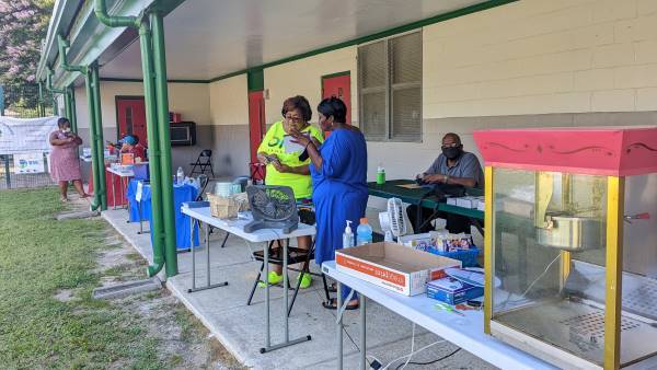 Two women talking at a booth.