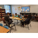 Teachers sitting with children while working on homework. 